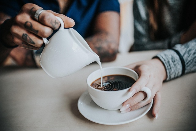 完成した陶器のカップでコーヒーを飲む女性