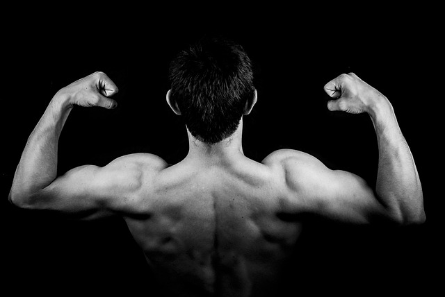 筋トレで引き締まった体を手に入れ、自信に満ちた笑顔でポーズをとる人物