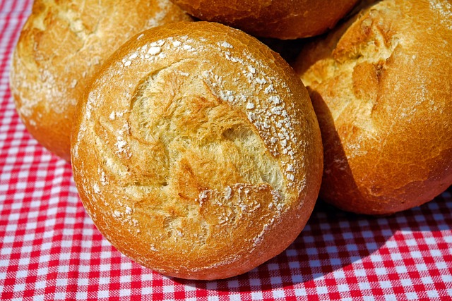 焼きたてのパンと計量カップ、キッチンスケールが並んだテーブル