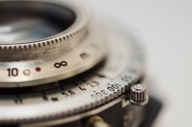 カメラにレンズを装着している手元をクローズアップし、ステップアップの始まりを象徴するイメージ