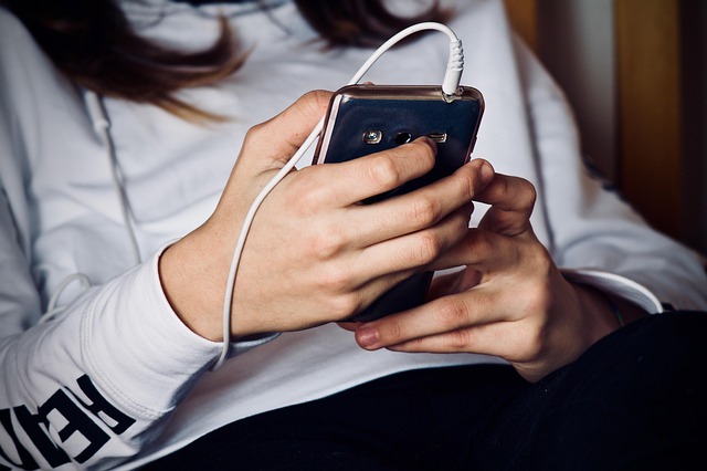 スマートフォンで照明を操作する笑顔の女性