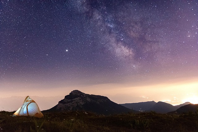 満点の星空の下で望遠鏡を覗き込む家族のシルエット