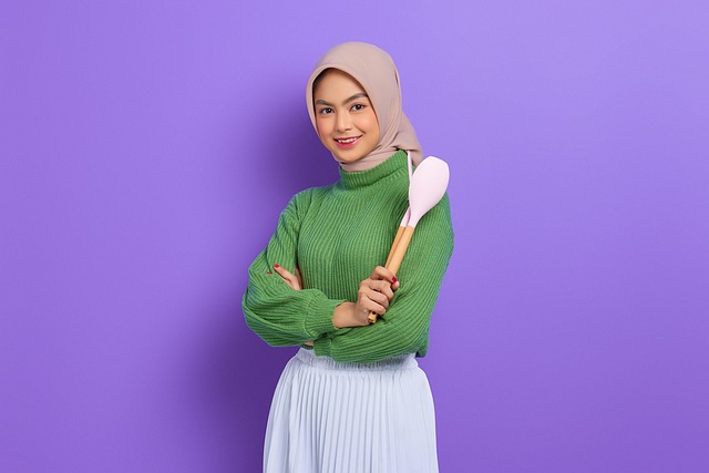 整理されたキッチンで笑顔で料理する女性