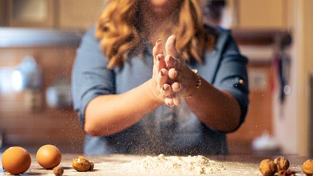 計量カップやボウルが並ぶキッチンでお菓子作りの準備をする手元