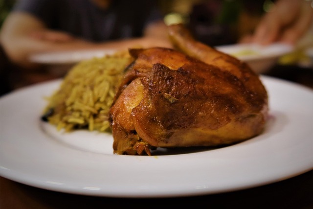 熱々のダッチオーブンから取り出されるローストチキン