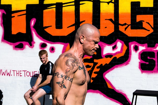 筋トレ初心者が無理なフォームでトレーニングし、トレーナーが注意を促している様子